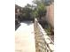 Backyard featuring a concrete patio, retaining wall, and mature trees at 6030 Halehaven Dr, Las Vegas, NV 89110