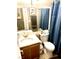 Bathroom featuring single sink vanity, toilet, shower with blue curtain, and a mirror at 6030 Halehaven Dr, Las Vegas, NV 89110