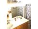 Bathroom featuring double sinks, wood cabinets, and a decorative shower curtain at 6030 Halehaven Dr, Las Vegas, NV 89110