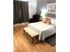 Bedroom showcasing hardwood floors, curtains, comfortable bed, and chair at 6030 Halehaven Dr, Las Vegas, NV 89110