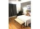 Bedroom showcasing hardwood floors, curtains, comfortable bed, and chair at 6030 Halehaven Dr, Las Vegas, NV 89110