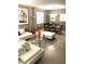 Open-concept living space with a white sectional, glass table, and a dining area under a chandelier at 6030 Halehaven Dr, Las Vegas, NV 89110