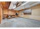 Garage featuring wood paneling, a workbench, cabinets, and concrete floors at 6205 Parsifal Pl, Las Vegas, NV 89107
