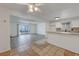 Open-concept living room and kitchen with tiled and wood floors, and a sliding glass door to the backyard at 6205 Parsifal Pl, Las Vegas, NV 89107