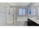 Bright bathroom featuring a tub and shower combination with glass doors and a large window at 6276 Point Isabel Way, Las Vegas, NV 89122