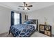 Comfortable bedroom with a ceiling fan, blue bedding, stylish decor, and natural light from the window at 6276 Point Isabel Way, Las Vegas, NV 89122