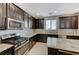Modern kitchen featuring dark cabinetry, stainless steel appliances, and granite countertops at 6276 Point Isabel Way, Las Vegas, NV 89122