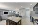 Open-concept living space featuring modern gray tones, island kitchen, and comfortable seating area with television at 6276 Point Isabel Way, Las Vegas, NV 89122