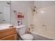 Cozy bathroom with a wooden vanity, toilet, and a bathtub with white tiling at 6641 Silverstream Ave # C, Las Vegas, NV 89107