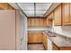 Well-lit kitchen featuring wood cabinets, stainless steel sink, and ample counter space at 6641 Silverstream Ave # C, Las Vegas, NV 89107