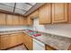 Charming kitchen with wood cabinets, stainless steel sink, and laminate countertops at 6641 Silverstream Ave # C, Las Vegas, NV 89107