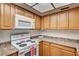 Functional kitchen with wood cabinets, an electric range, and plenty of counter space at 6641 Silverstream Ave # C, Las Vegas, NV 89107