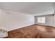 Bright living room features wood-look floors, a large window, and access to the staircase at 6641 Silverstream Ave # C, Las Vegas, NV 89107