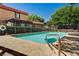 Community pool featuring crystal clear water surrounded by a safety fence and building exterior at 6641 Silverstream Ave # C, Las Vegas, NV 89107