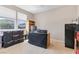 Bedroom with a covered desk and storage containers, illuminated by natural light from two windows at 7070 Cinder Horse St, Las Vegas, NV 89131
