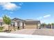 Single-story home with a brick driveway, a two-car garage, desert landscaping, and a decorative gate at 7070 Cinder Horse St, Las Vegas, NV 89131