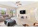 Well-lit living room featuring comfortable seating, a TV, and sliding glass doors leading to the backyard at 7070 Cinder Horse St, Las Vegas, NV 89131