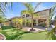 Beautiful backyard with a putting green, palm trees, and a covered patio perfect for outdoor entertaining at 724 Step Beach St, Las Vegas, NV 89138