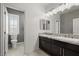 Bathroom featuring double vanity, marble countertops, and gray textured wallpaper at 724 Step Beach St, Las Vegas, NV 89138