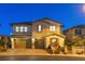 Exterior of a two-story home with a stone accent, two-car garage, and well-manicured landscaping at 724 Step Beach St, Las Vegas, NV 89138