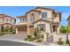 Beautiful two-story home featuring stone accents, a three-car garage, and professionally landscaped front yard at 724 Step Beach St, Las Vegas, NV 89138