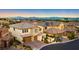 Aerial view of stucco home showcasing a two-car garage, a well-manicured lawn, and a tile roof at 724 Step Beach St, Las Vegas, NV 89138