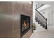 Stylish fireplace with modern tile surround, staircase, and potted plant at 724 Step Beach St, Las Vegas, NV 89138