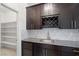 Butler's pantry features wine rack, stainless sink, granite counters, tile backsplash, and brown cabinets at 724 Step Beach St, Las Vegas, NV 89138