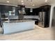 Modern kitchen boasts stainless steel appliances, granite counters, large island and dark cabinetry at 724 Step Beach St, Las Vegas, NV 89138