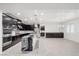 Modern kitchen with stainless steel appliances, sleek dark cabinets, a large island, and elegant lighting at 724 Step Beach St, Las Vegas, NV 89138