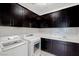 Laundry room with dark cabinets, modern appliances, and a stylish backsplash at 724 Step Beach St, Las Vegas, NV 89138
