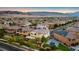 An aerial view showcases a neighborhood near mountains at sunset at 724 Step Beach St, Las Vegas, NV 89138