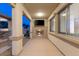 Inviting covered patio with stone fireplace, mounted TV, and views of the landscaped backyard at twilight at 724 Step Beach St, Las Vegas, NV 89138