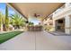 Covered outdoor kitchen with barstool seating, fireplace, TV, and putting green at 724 Step Beach St, Las Vegas, NV 89138