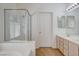 Bathroom with a glass shower, separate tub, tiled walls and a bright double vanity at 7927 W Oquendo Rd, Las Vegas, NV 89113