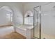Bright bathroom featuring a glass shower, a separate tub, and arched window above at 7927 W Oquendo Rd, Las Vegas, NV 89113