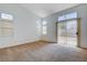 Large bedroom featuring neutral carpets, bright windows, and sliding patio doors at 7927 W Oquendo Rd, Las Vegas, NV 89113