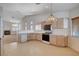 Spacious kitchen with white countertops, wooden cabinets, and views into the living room at 7927 W Oquendo Rd, Las Vegas, NV 89113