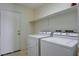 Functional laundry room equipped with appliances, top shelf, and a bright ceiling light at 7927 W Oquendo Rd, Las Vegas, NV 89113