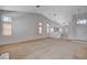 Bright living room with neutral carpeting, vaulted ceiling, and ample natural light from large windows at 7927 W Oquendo Rd, Las Vegas, NV 89113