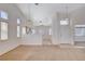 Open living room with neutral carpet, high ceilings, and an open view into the kitchen area at 7927 W Oquendo Rd, Las Vegas, NV 89113