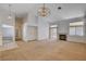 Spacious living room with neutral carpeting, fireplace, and access to hallway and outdoor space at 7927 W Oquendo Rd, Las Vegas, NV 89113