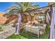 Serene backyard oasis offers a covered lounge area, dining space, and lush landscaping for relaxing and entertaining at 8136 Shady Glen Ave, Las Vegas, NV 89131