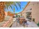 A charming backyard patio includes a table, chairs, grill, and string lights surrounded by mature tropical foliage at 8136 Shady Glen Ave, Las Vegas, NV 89131
