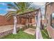 Backyard featuring a gazebo with curtains, lush artificial grass, and a mature palm tree at 8136 Shady Glen Ave, Las Vegas, NV 89131