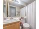 Cozy bathroom features a single sink vanity, large mirror, and a shower with white curtain at 8136 Shady Glen Ave, Las Vegas, NV 89131