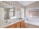 Bathroom with a large mirror, dual sinks, separate tub, and a window with natural light at 8136 Shady Glen Ave, Las Vegas, NV 89131