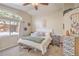 Bright bedroom features a neutral palette, ceiling fan, and large window offering plenty of natural light at 8136 Shady Glen Ave, Las Vegas, NV 89131