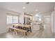 Bright dining area features a large window, light wood floors, and a wood dining table with benches and chairs at 8136 Shady Glen Ave, Las Vegas, NV 89131
