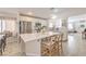 This updated kitchen includes an island with seating, white countertops, and stainless steel appliances in an open-concept design at 8136 Shady Glen Ave, Las Vegas, NV 89131
